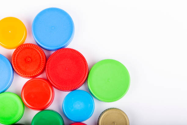 istock Many multi-colored plastic bottle caps on a white background. Recycling concept. Space for text. 1288305173