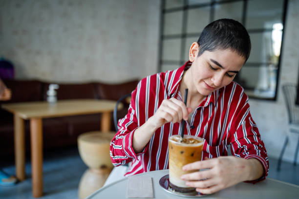 istock Young Bald Woman Drink Iced Pumpkin Spice Latte 1288305905