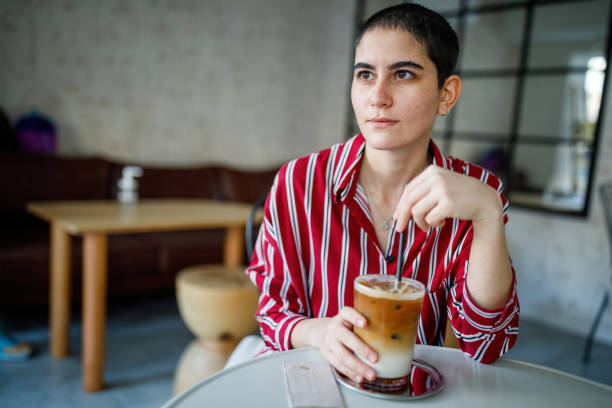 istock Young Bald Woman Drink Iced Pumpkin Spice Latte 1288306029