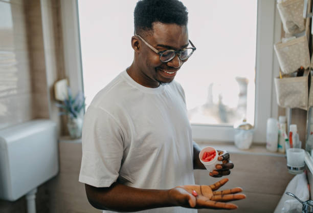 istock Young man takes vitamin in the morning 1288313122