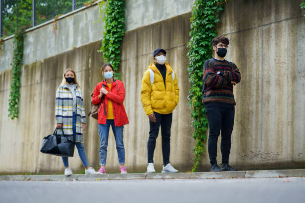 istock Young people standing outdoors in town. Coronavirus and safe distance concept. 1288314487