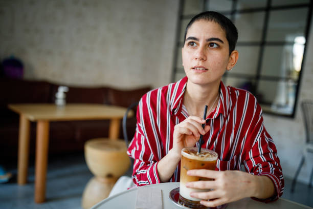 istock Young Bald Woman Drink Iced Pumpkin Spice Latte 1288314574