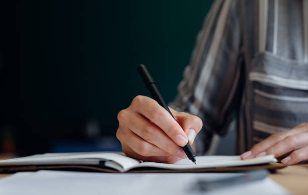 istock Close up Shot of an Anonymous Young Businesswoman's Hands Taking Notes while Working from Home on a Laptop 1288318041