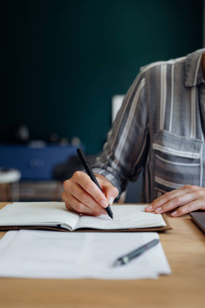 istock Close up Shot of an Anonymous Young Businesswoman's Hands Taking Notes while Working from Home on a Laptop 1288318043