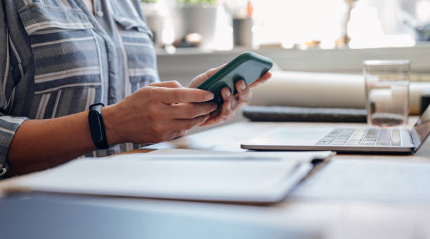 istock Close up Shot of an Anonymous Young Businesswoman's Hands Using a Mobile Phone while Working from Home 1288318044