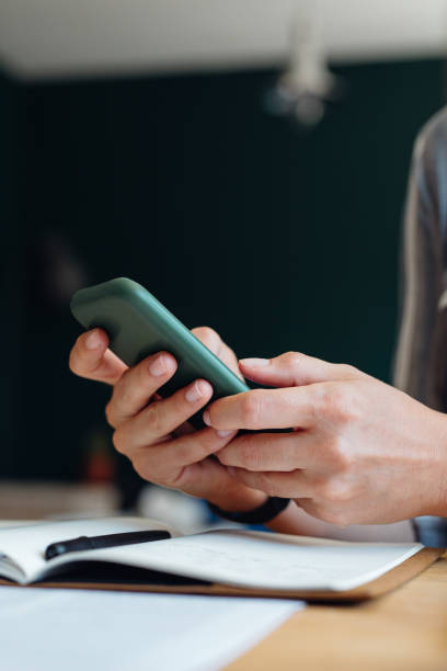 istock Close up Shot of an Anonymous Young Businesswoman's Hands Using a Mobile Phone while Working from Home 1288318054
