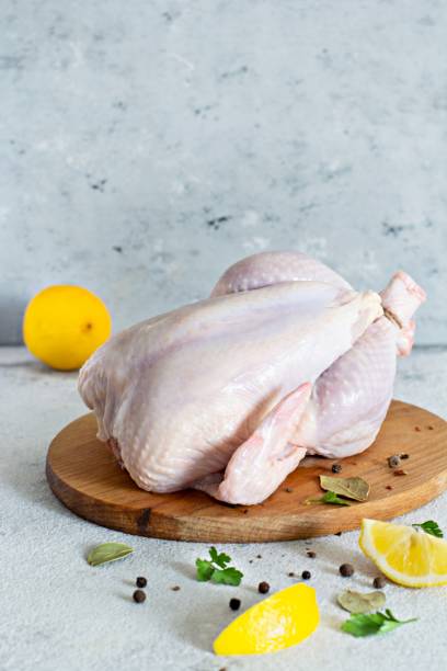 istock Raw chicken carcass ready for cooking on a cutting board on a gray background. 1288318840
