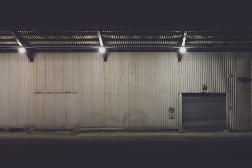 Shuttered entrance to an industrial warehouse building protected by CCTV.  Belfast, Northern Ireland.