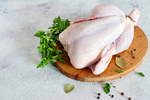 istock Raw chicken carcass ready for cooking on a cutting board on a gray background. 1288322548
