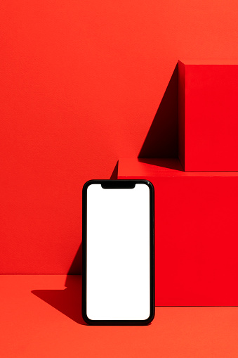 Blank white screen smart phone mockup, template on red background.