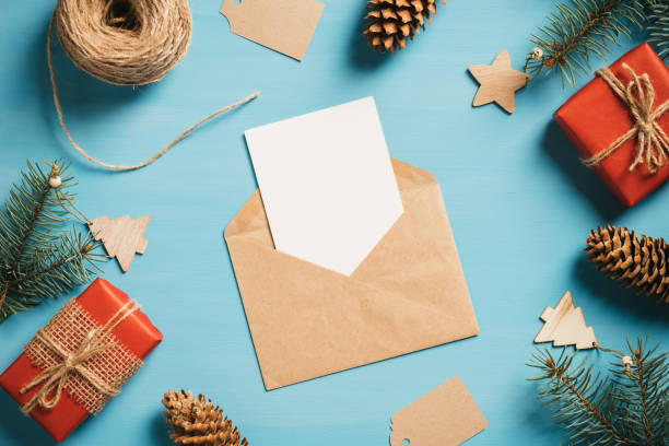 istock Vintage Christmas flat lay composition. Blank paper card, envelope, gift boxes, pine branches and Xmas decorations. Top view with copy space. Retro style greeting card. 1288325985