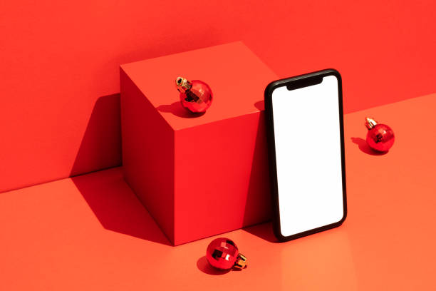 istock Blank white screen smart phone mockup, template on red Christmas background 1288325995