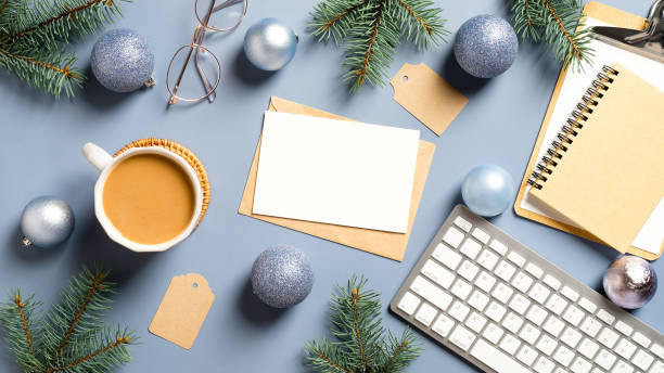 istock Home office workspace with keyboard, coffee cup, notebook, glasses, pine branches, balls and Christmas decorations. Flat lay, top view winter holiday composition. 1288326088