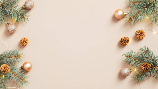 istock Christmas frame. Christmas tree branches with cones and balls on pastel beige background. Xmas or New Year greeting card template. 1288326154