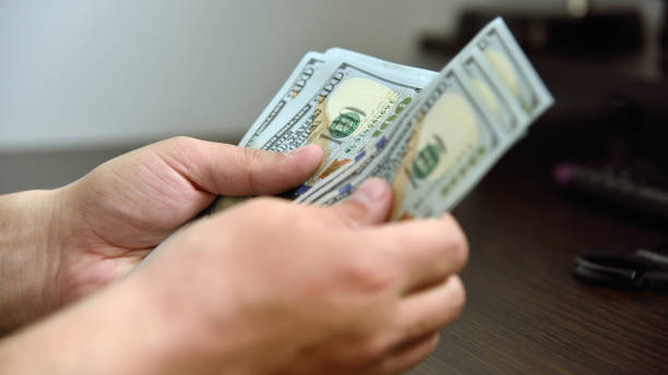 istock Businessman hands counts money 1288328190