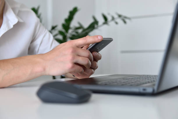 istock Businessman hand with mobile phone looking on business plan. 1288328238