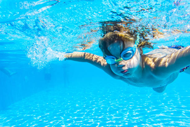 istock Cute boy with swimming goggles underwater 1288330872