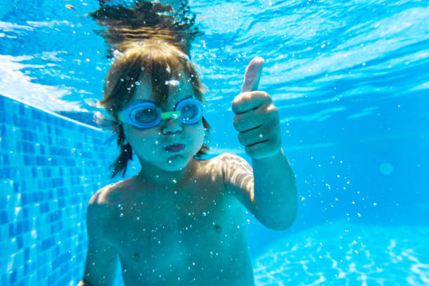 istock Little boy diving in swimming pool 1288330914