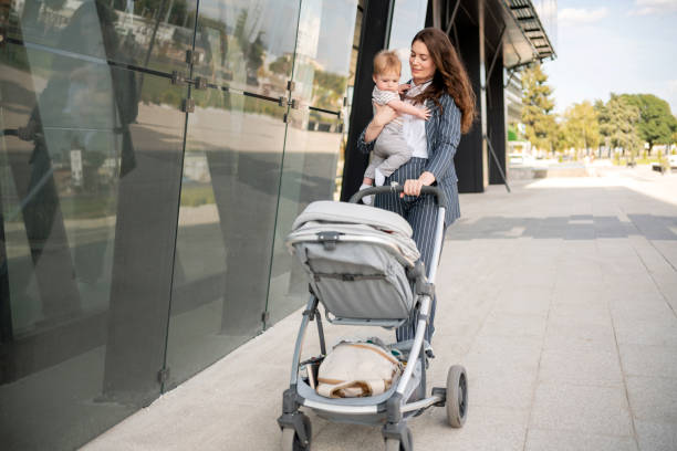 istock Mother pushing a baby stroller while carrying her child 1288332003