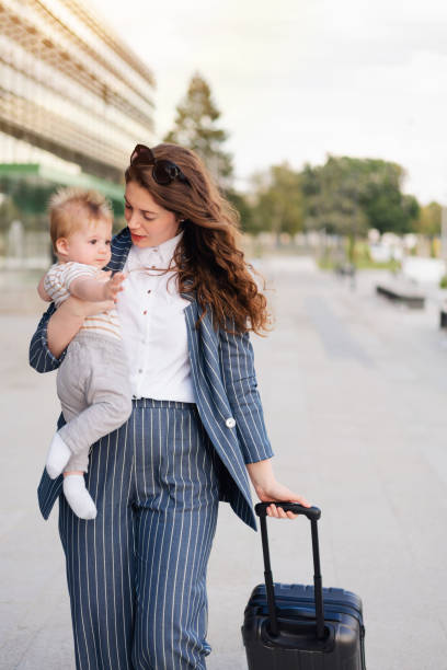 istock Young mother talking to her baby while dragging the luggage 1288332027