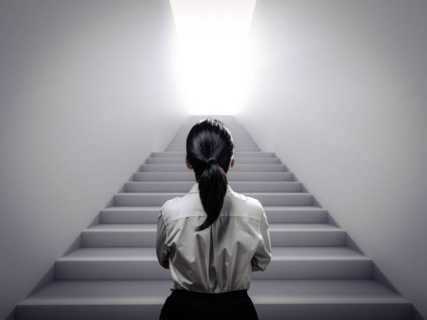 businesswoman standing at staircase Rear view businesswoman standing at staircase climbing staircase stock pictures, royalty-free photos & images