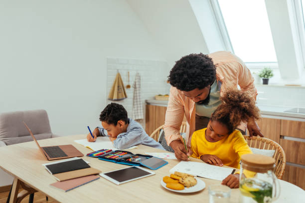 istock Father helping his children with their homework 1288333665