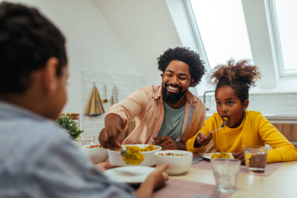 istock Afro family eating lunch together around the kitchen table 1288333676