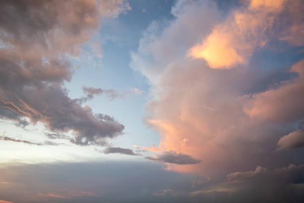 istock Dramatic sunset landscape with puffy clouds lit by orange setting sun and blue sky. 1288333866