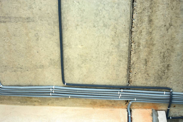 istock Electrical cables laid in protective corrugation installed on the ceiling and wall in a room under construction works. 1288333913