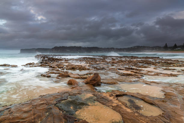 istock Rock platform, cascades and splashes with rain clouds by the seaside 1288335510