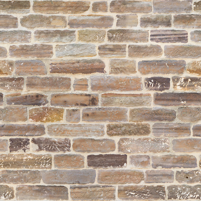 A very old masonry wall made from sandstone bricks that tiles seamlessly in all directions.