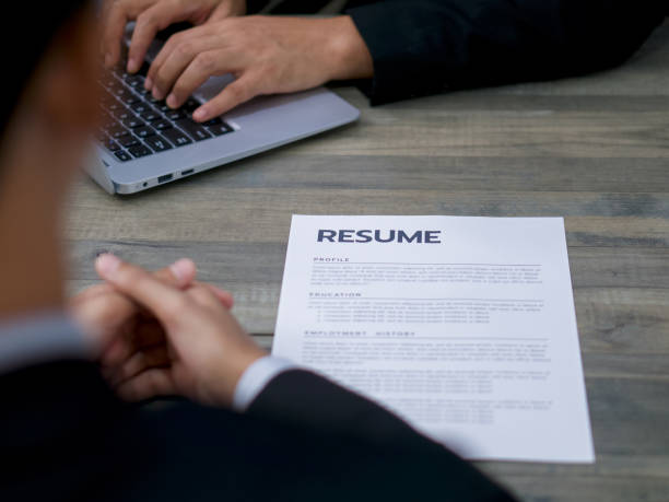 istock Human Resources staff input information from the applicant's resume into the company database by laptop computer. 1288357141