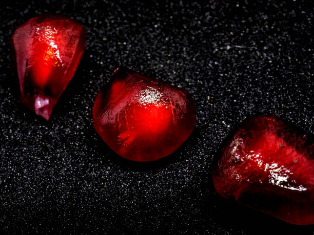 istock red grains of ripe pomegranate on a black background, macro 1288358691