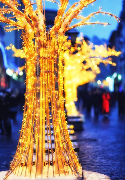 istock Christmas artificial trees with lights on city streets in the evening 1288367369