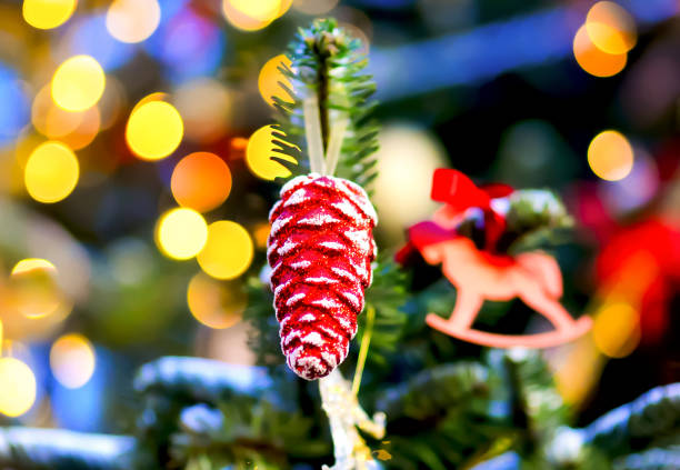 istock Christmas toy - a red cone on a New Year tree on a blurred background with lights 1288367399