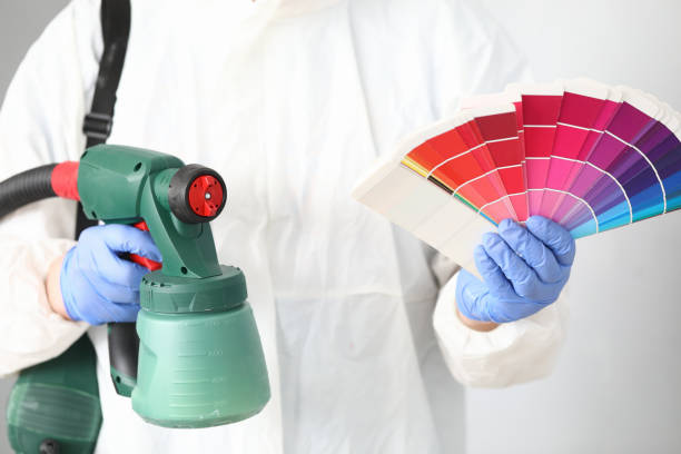 man holds in his hands spray gun and palette of colors. - home decorator house painter color swatch paint imagens e fotografias de stock