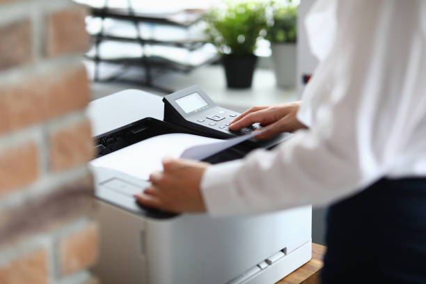 woman in office prints documents on printer - print computer printer printout push button imagens e fotografias de stock