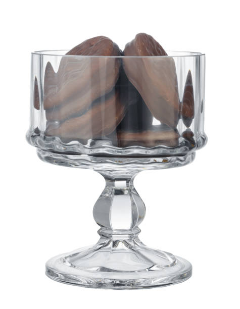 Glass cookie jar with chocolate chip cookies inside on white background