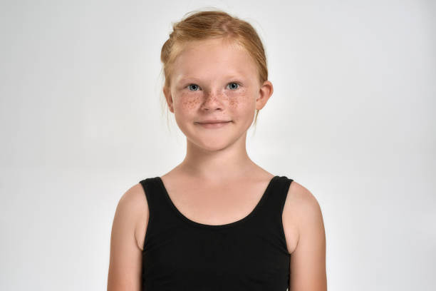 portrait of pretty little red haired sportive girl in sportswear smiling at camera while standing isolated over white background - gymnastics smiling little girls only isolated on white imagens e fotografias de stock