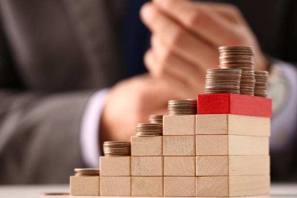 istock Stack of coins on wooden cubes in stair shape 1288374811