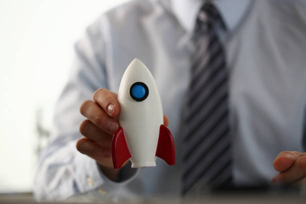 istock Businessman holding small toy rocket in the office 1288374822