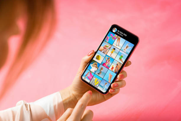 mujer sosteniendo el teléfono y mirando la galería de fotos de otra persona - influencer fotos fotografías e imágenes de stock