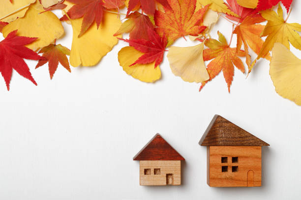 istock Autumn leaves and miniature house 1288376590