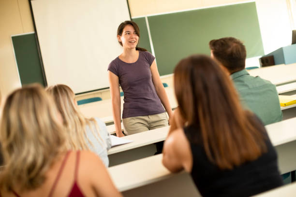 universitätsstudenten im klassenzimmer mit junger dozentin - studygroup stock-fotos und bilder