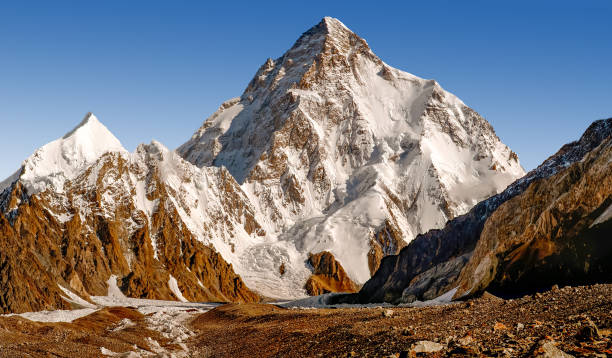 Majestic view of the K2 summit K2, at 8,611 metres above sea level, is the second highest mountain in the world, after Mount Everest at 8,848 metres. It is located on the China–Pakistan border between Baltistan in the Gilgit-Baltistan region of northern Pakistan k2 mountain panorama stock pictures, royalty-free photos & images