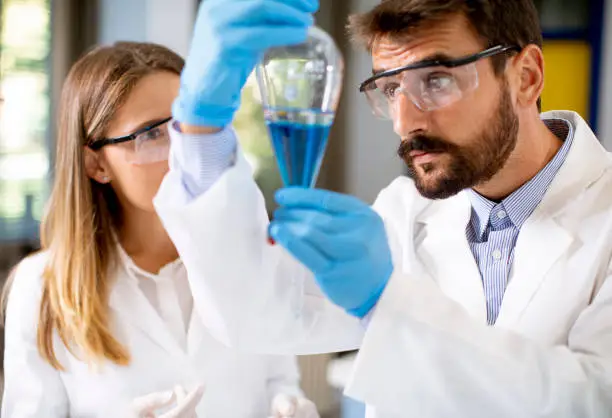 Photo of Researcher working with blue liquid at separatory funnel