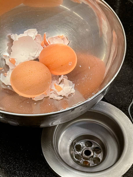 Pelar los huevos cocidos en un tazón con agua - foto de stock