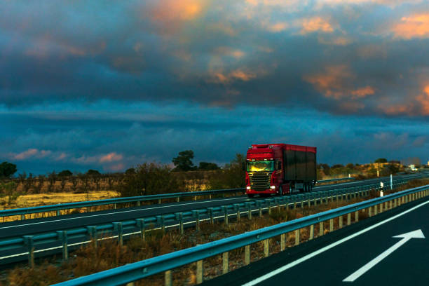 istock Red truck driving on a highway 1288392244