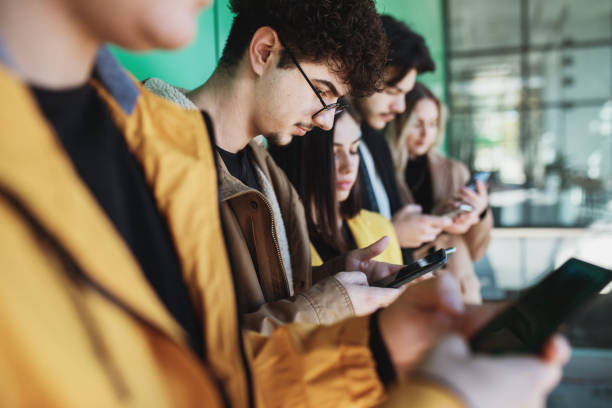 istock Young people looking at smartphones 1288395747