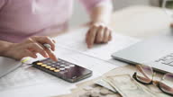 istock Close-up Hand Woman Using Calculator form Smart phone for Taxes And Budget At Home 1288396768